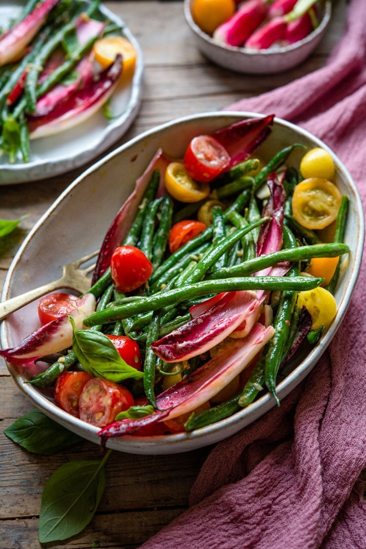 A side shot of a green bean salad in a large serving bowl