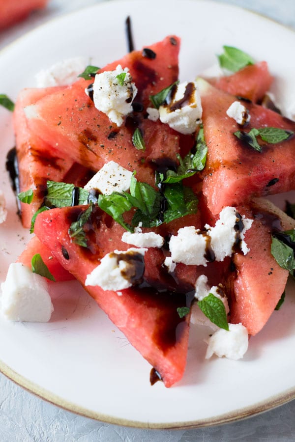 A delicious light watermelon basil salad with mint, goats and balsamic glaze. Refreshing and healthy salad recipe insidetherustickitchen