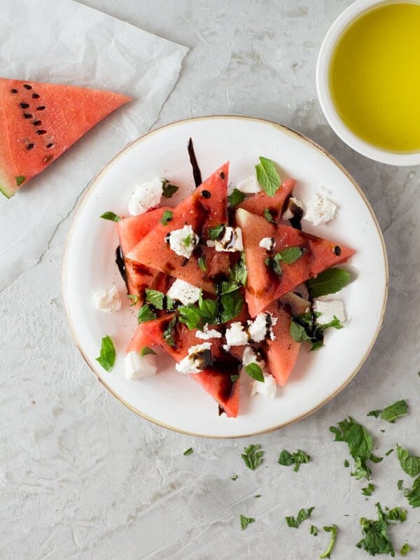 A delicious light watermelon basil salad with mint, goats and balsamic glaze. Refreshing and healthy salad recipe insidetherustickitchen