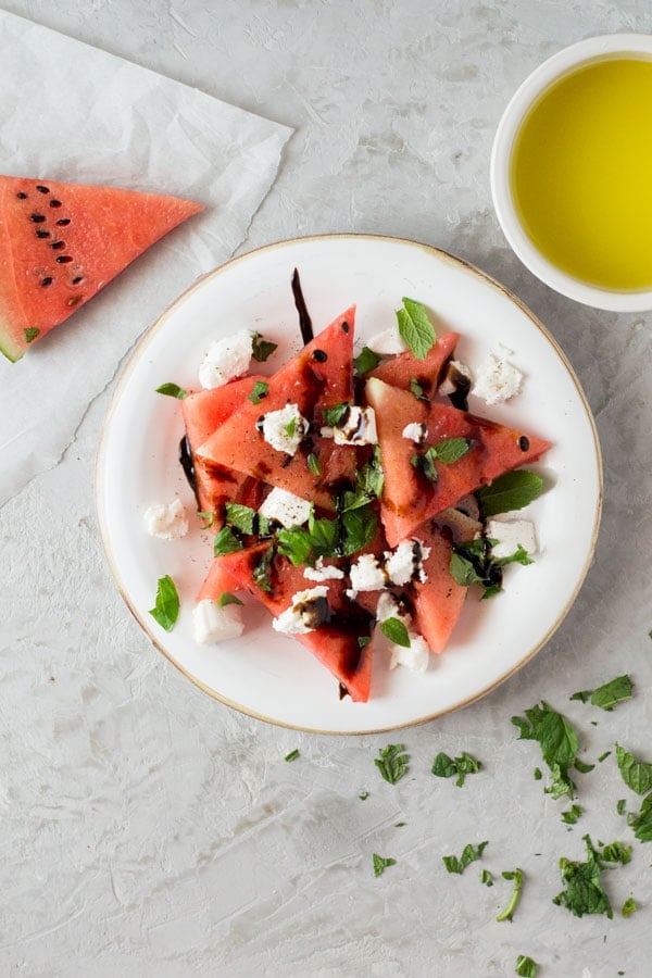 A delicious light watermelon basil salad with mint, goats and balsamic glaze. Refreshing and healthy salad recipe insidetherustickitchen