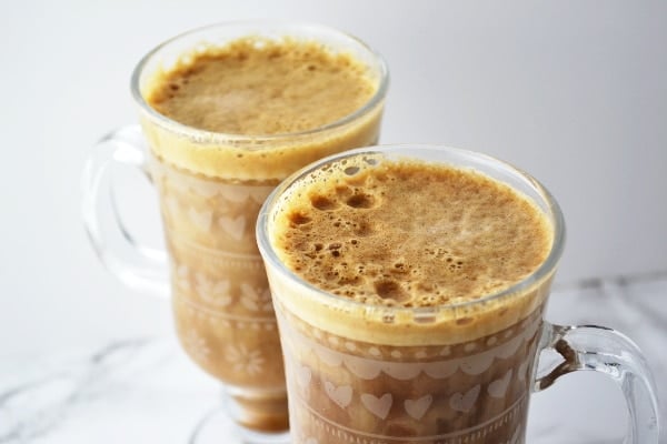 Tow glasses of banana milk coffee on a white surface