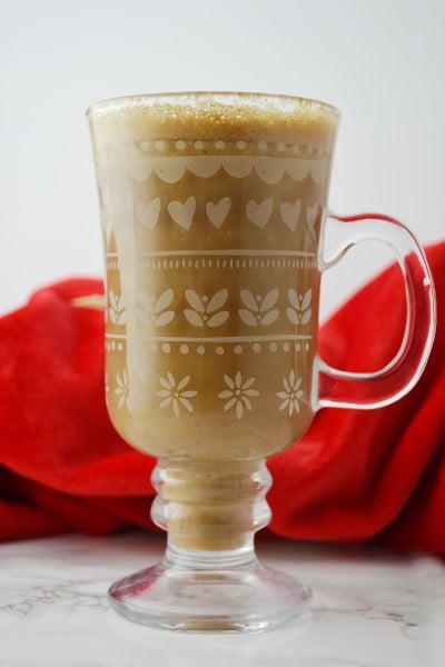 Banana milk coffee in a glass mug on a white surface