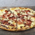 An insanely delicious Cheesy Speck and Mushroom Pizza recipe that is guaranteed to be your new favourite. www.insidetherustickitchen.com