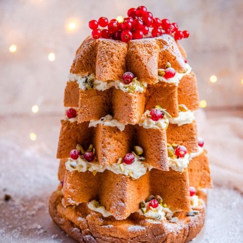 A pandoro christmas cake topped with redcurrants and nuts