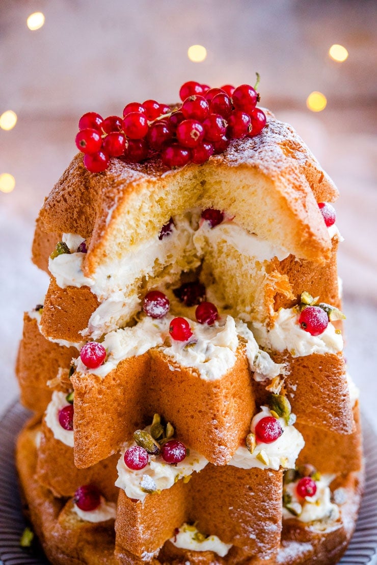A close up of a pandoro christmas tree cake with a slice missing