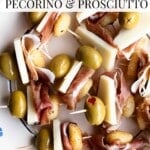 Gnocchi appetizes on a plate with olives, pecorino and prosciutto.