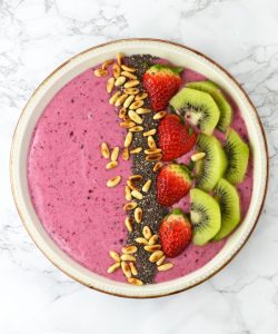 This Berry Banana Smoothie Bowl recipe is filled with delicious berries, banana, honey and is topped with chopped fruit and toasted pine nuts. www.insidetherustickitchen.com