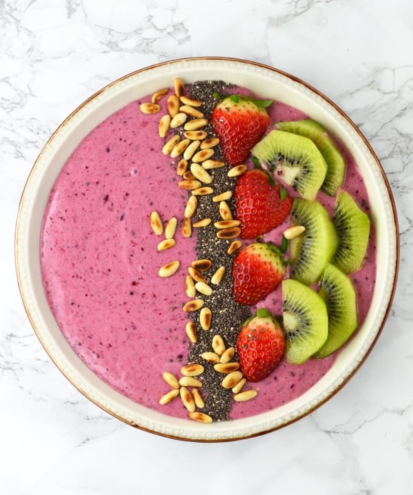 This Berry Banana Smoothie Bowl recipe is filled with delicious berries, banana, honey and is topped with chopped fruit and toasted pine nuts. www.insidetherustickitchen.com