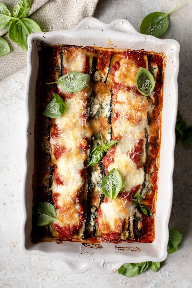 An overhead shot of eggplant rollatini with spinach and ricotta in a baking dish