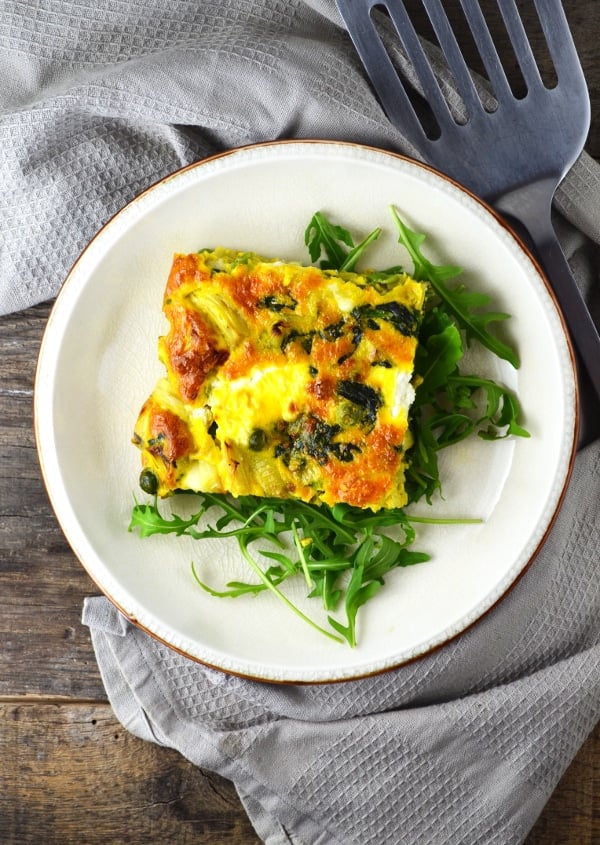 This Artichoke and Spinach Frittata is perfect for a light lunch this Spring with peas, leek and goats cheese it is packed full of flavour! www.insidetherustickitchen.com