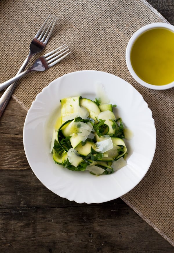 A fresh, Summer Zucchini Ribbon Salad with a simple tart lemon dressing, arugula, and shavings of parmesan. It's light, easy and super delicious. insidetherustickitchen.com
