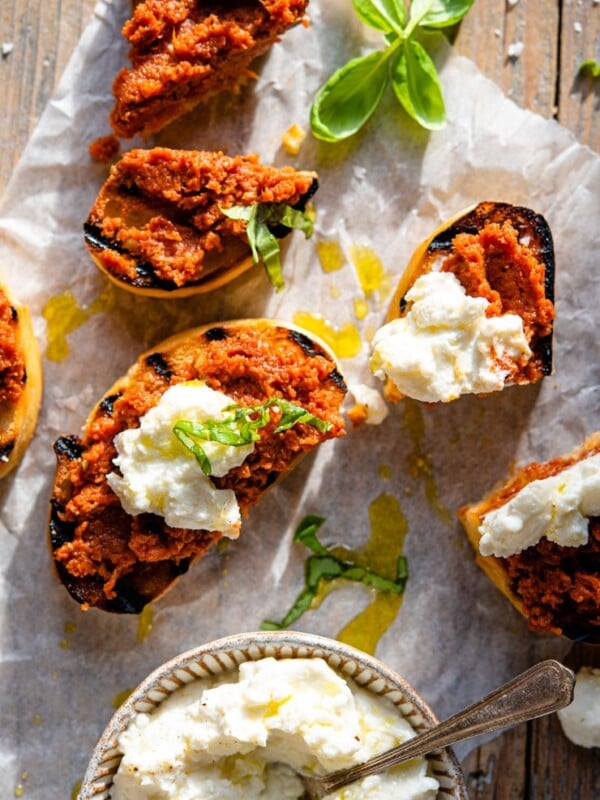 An overhead shot of red pesto on ciabatta bread with ricotta