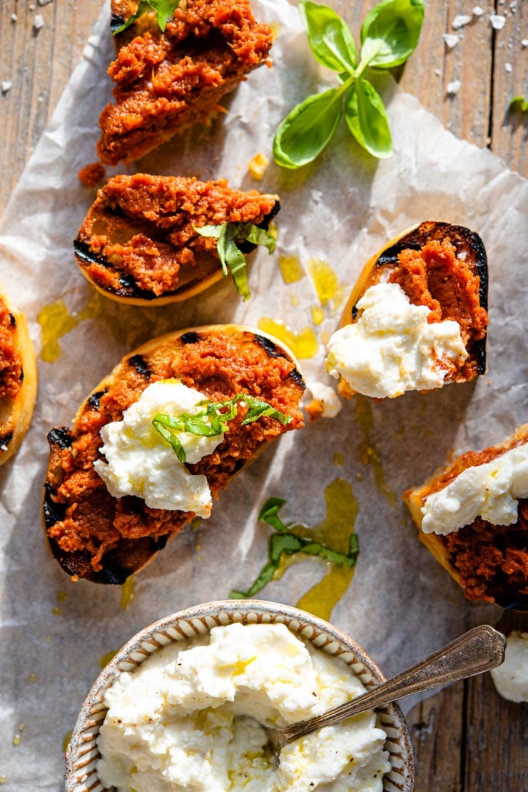 An overhead shot of red pesto on ciabatta bread with ricotta