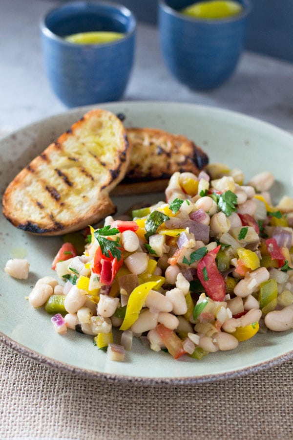 A warm easy bean salad recipe with yellow pepper, eggplant, tomatoes, garlic and delicious fresh herbs. This makes a perfect easy, simple and delicoius dinner or lunch alongside some char grilled crusty bread. insidetherustickitchen.com