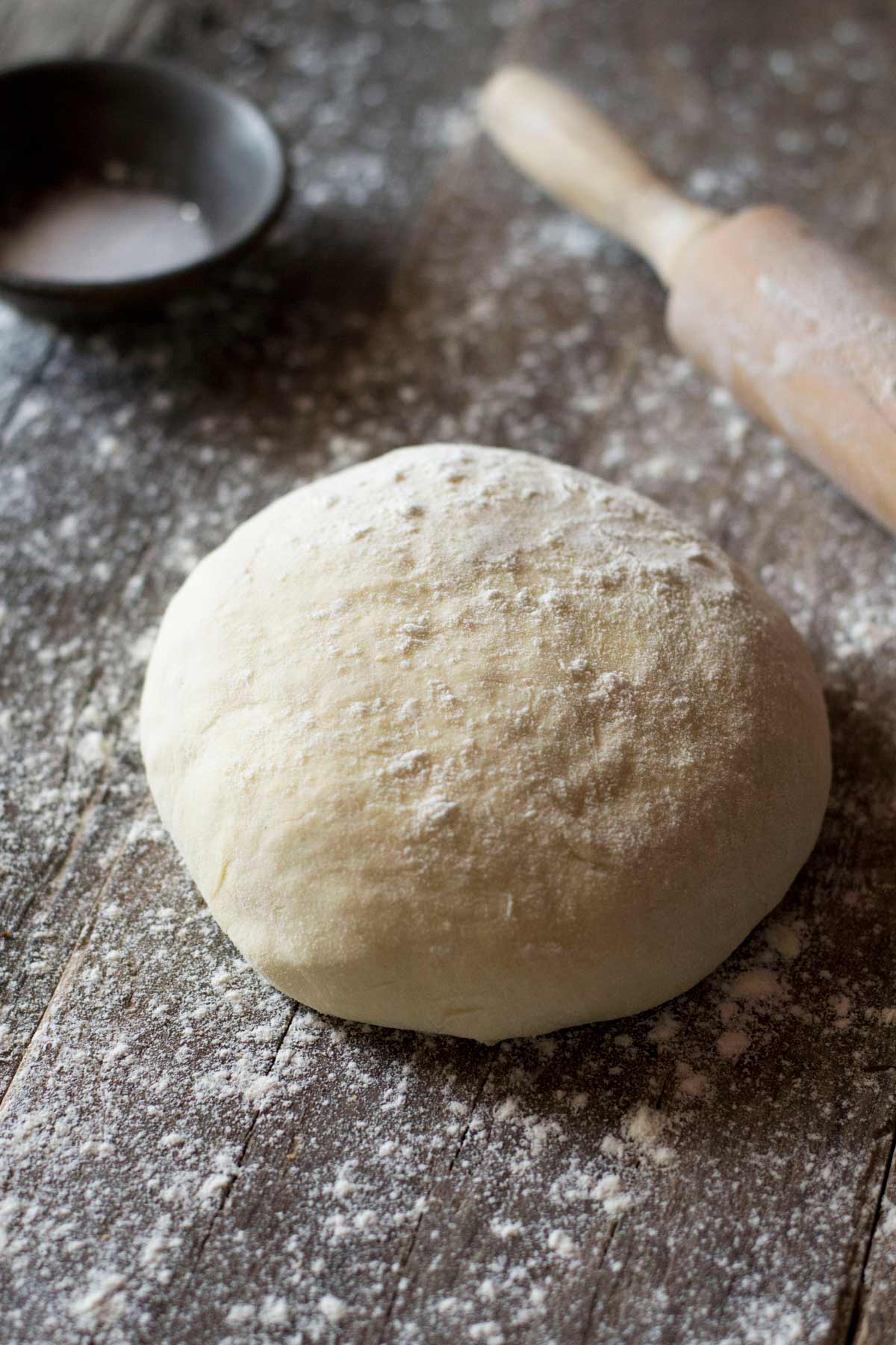 A ball of yeast free pizza dough on a wooden work surface