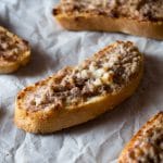 This two ingredient stracchino and sausage crostini is so simple and crazy delicious. Tangy, soft cheese is mixed with Italian sausage and spread on some thick crusty bread. An easy sausage crostini recipe you're sure to love. More authentic italian recipes at Insidetherustickitchen.com