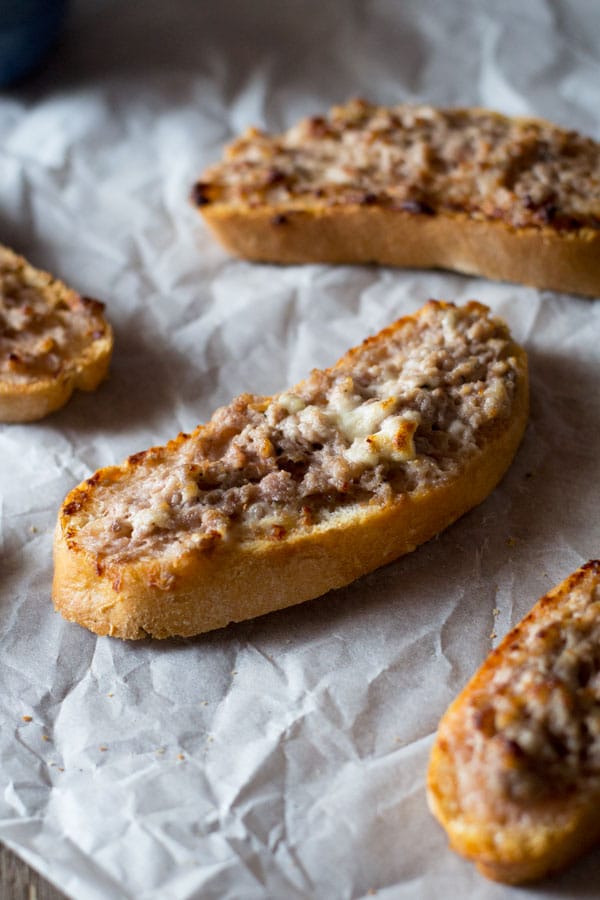 This two ingredient stracchino and sausage crostini is so simple and crazy delicious. Tangy, soft cheese is mixed with Italian sausage and spread on some thick crusty bread. An easy sausage crostini recipe you're sure to love. More authentic italian recipes at Insidetherustickitchen.com