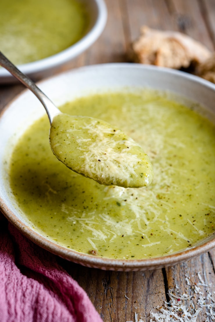 A close up of a spoonful of creamy zucchini soup 