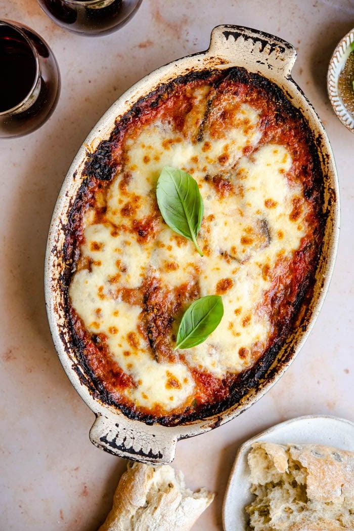 An overhead shot of eggplant parmigiana in a rustic casserole dish