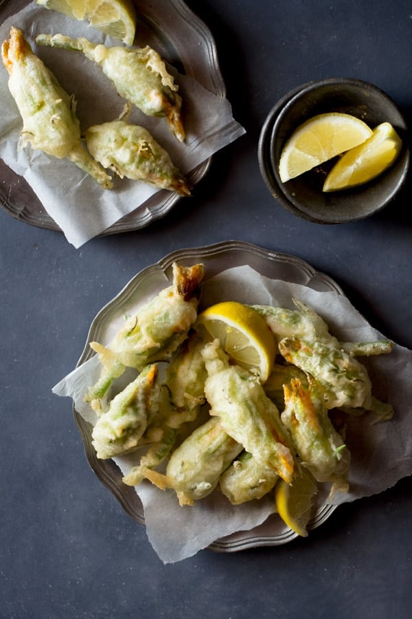 Crispy, deep fried ricotta stuffed zucchini flowers with lemon and chili flakes. An easy, elegant and fun Italian appetizer that's hard to resist. How to fry zucchini flowers and recipe at Inside the rustic kitchen - authentic Italian recipes.