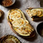 A cropped image of eggplant bruschetta topped with melted mozzarella.