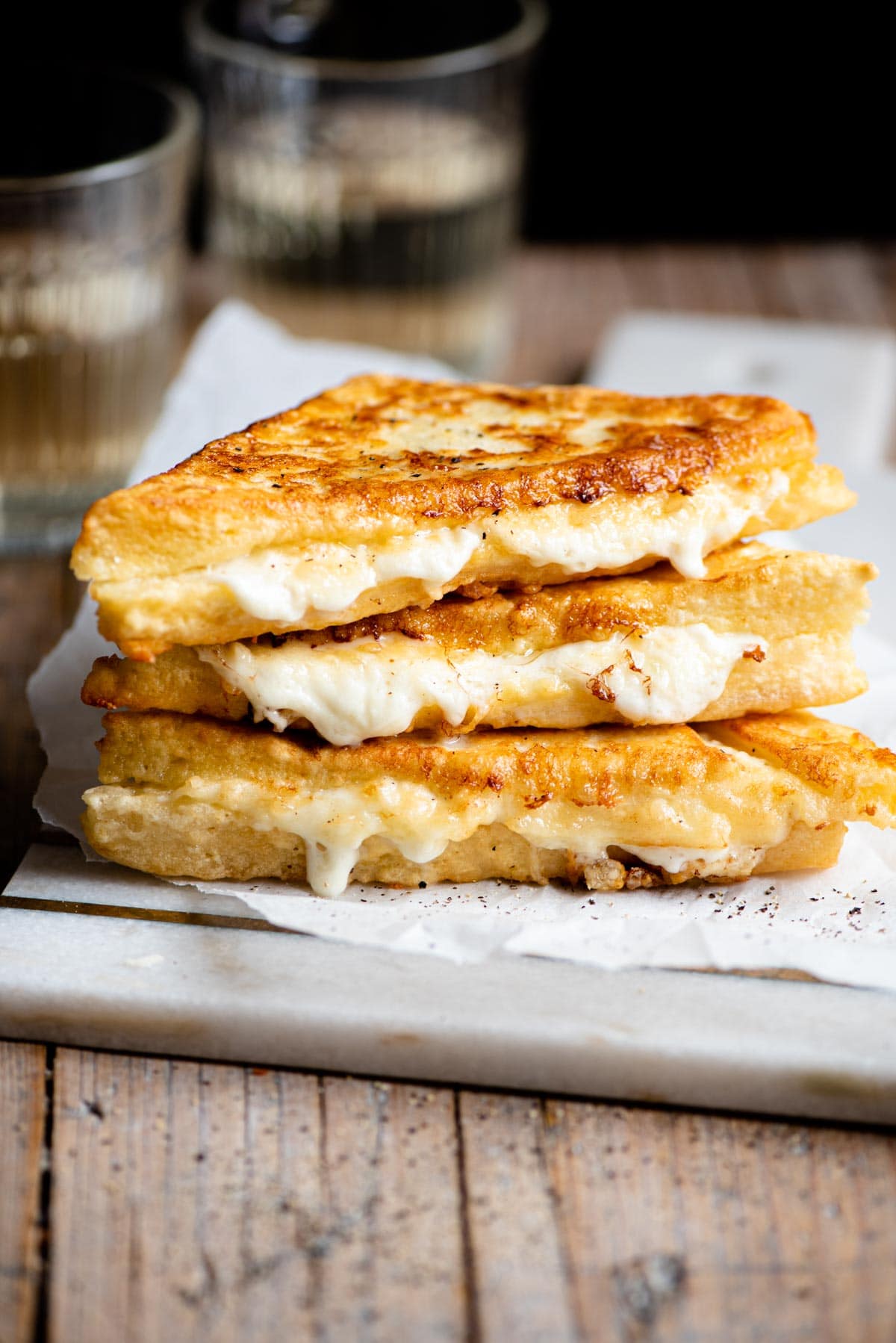 Three fried mozzarella sandwiches stacked on top of each other