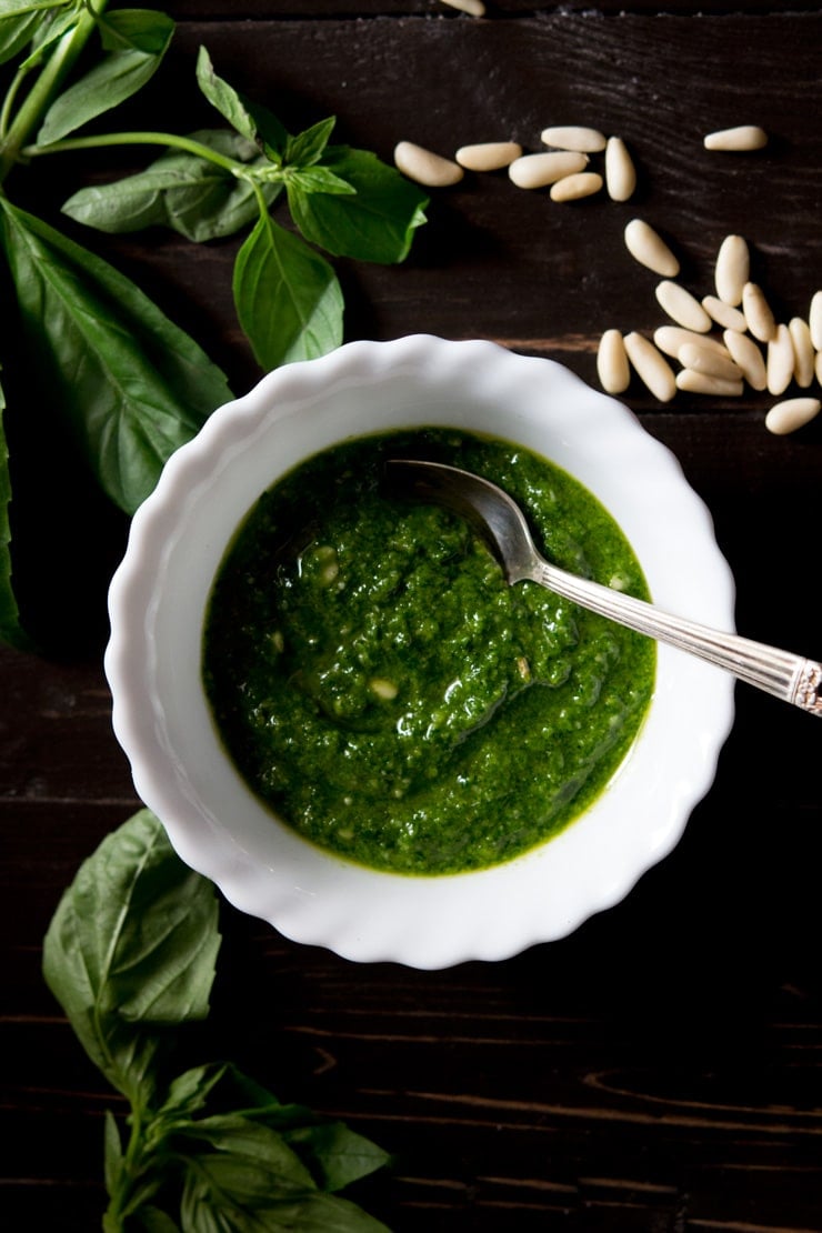 Recipe for how to make basil pesto, pesto in a bowl with basil and pine nuts