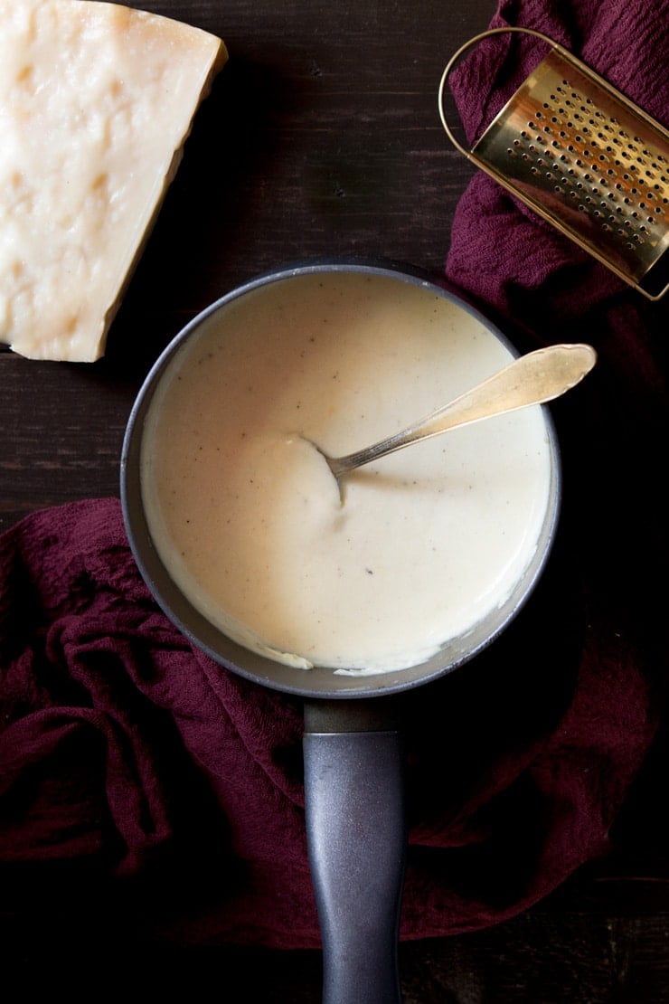 overhead shot of white sauce in a saucepan. How to make bechamel sauce recipe