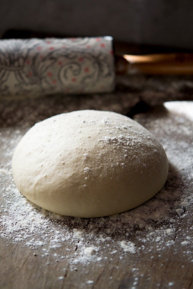The best basic pizza dough recipe sitting on a floured work surface
