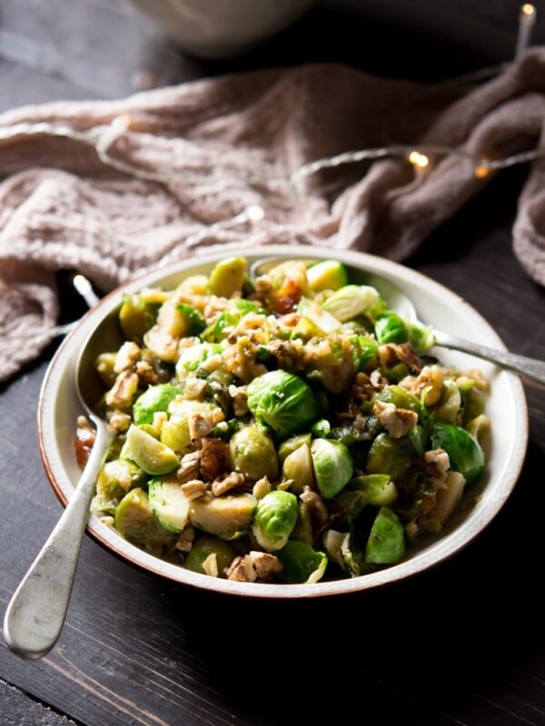 sauteed brussels sprouts with dates and walnuts on a plate on a wooden surface