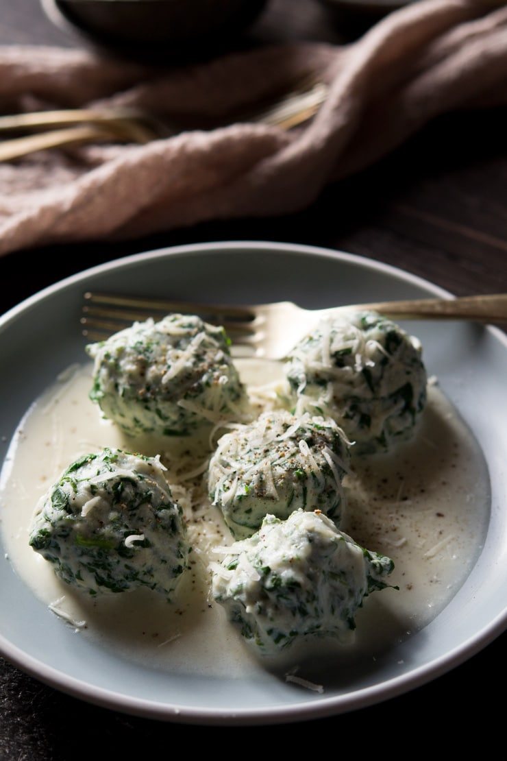 A close up of broccoli rabe and ricotta gnudi in a parmesan cream