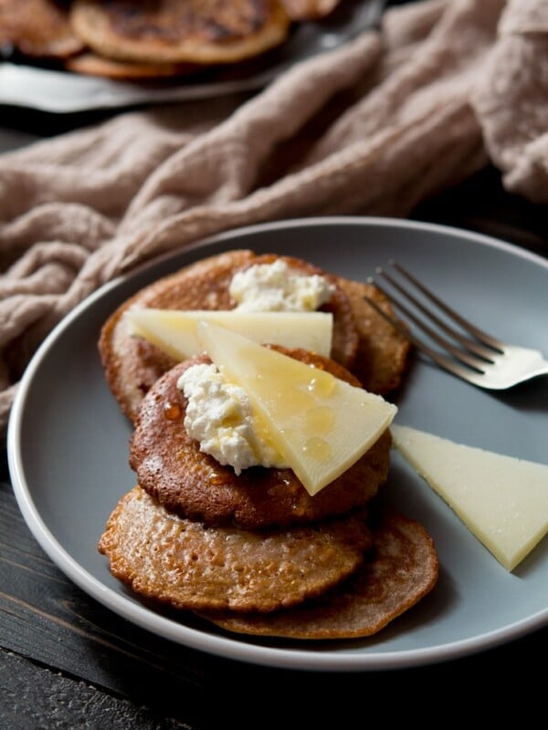 chestnut fritters on a plate topped with ricotta and pecorino cheese