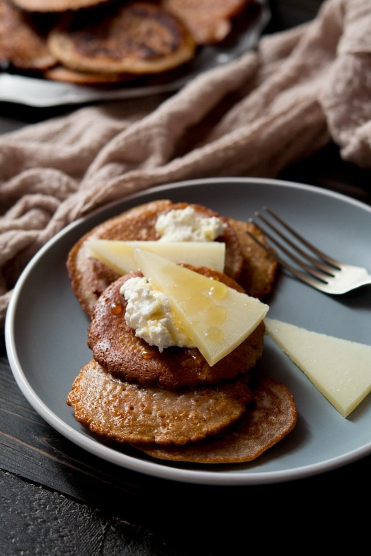 chestnut fritters topped with ricotta, pecorino cheese and honey on a blue plate