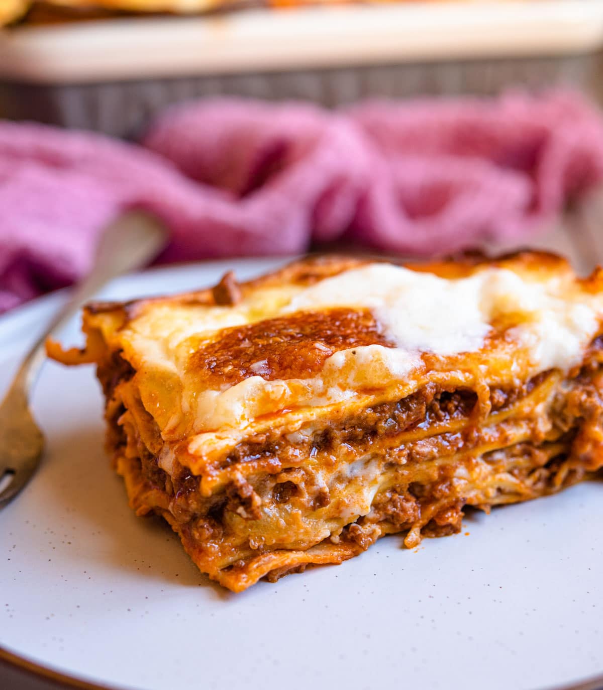 A close up of a slice of lasagne al forno on a plate