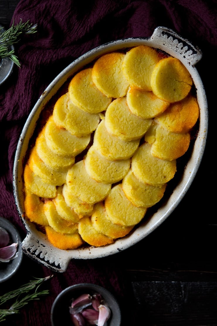 Baked polenta with sausage and beef ragu in a baking dish