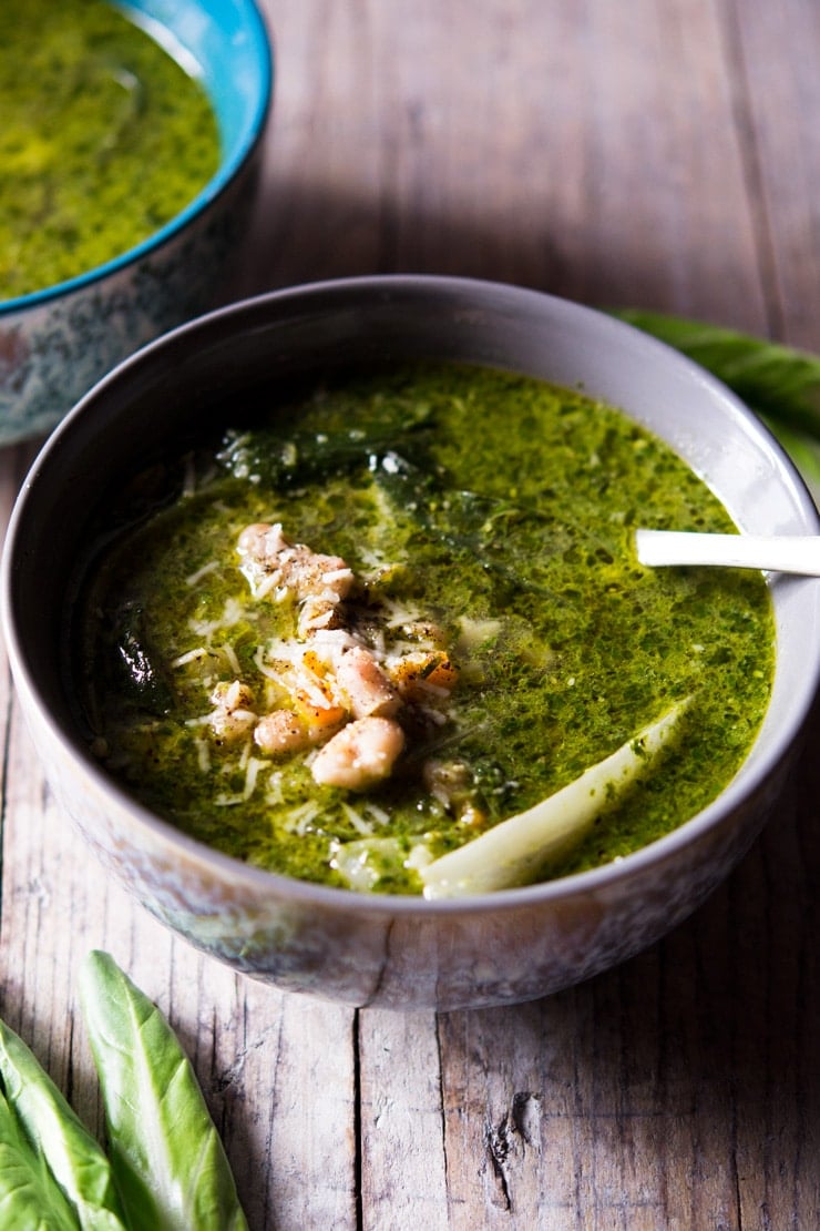 A bowl of green soup topped with beans and green vegetables