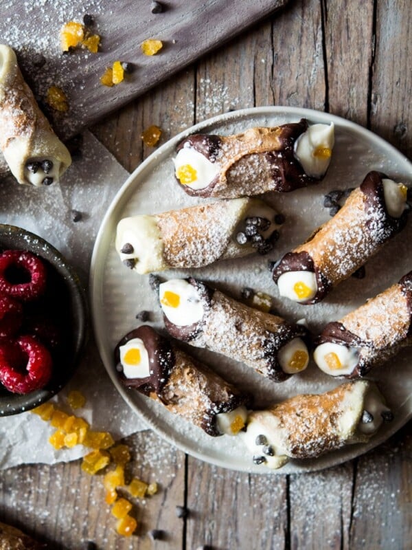 Mini cannoli on a plate with candied orange