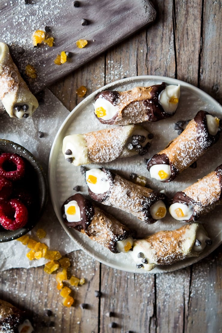 Mini cannoli on a plate with candied orange