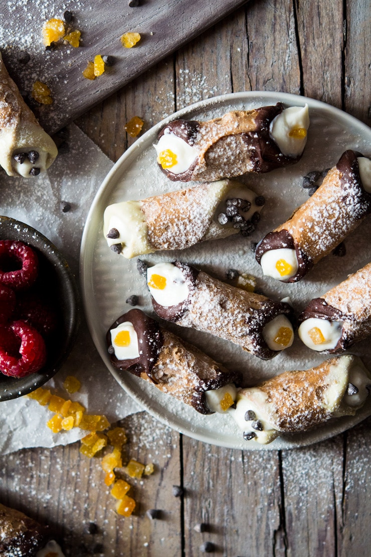 mini cannoli with orange and dark chocolate on a wooden surface