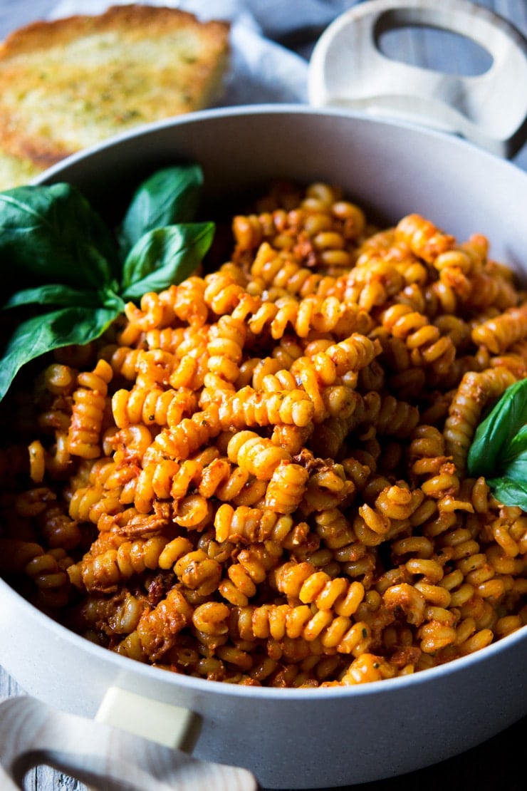 a close up of sun dried tomato pasta and basil