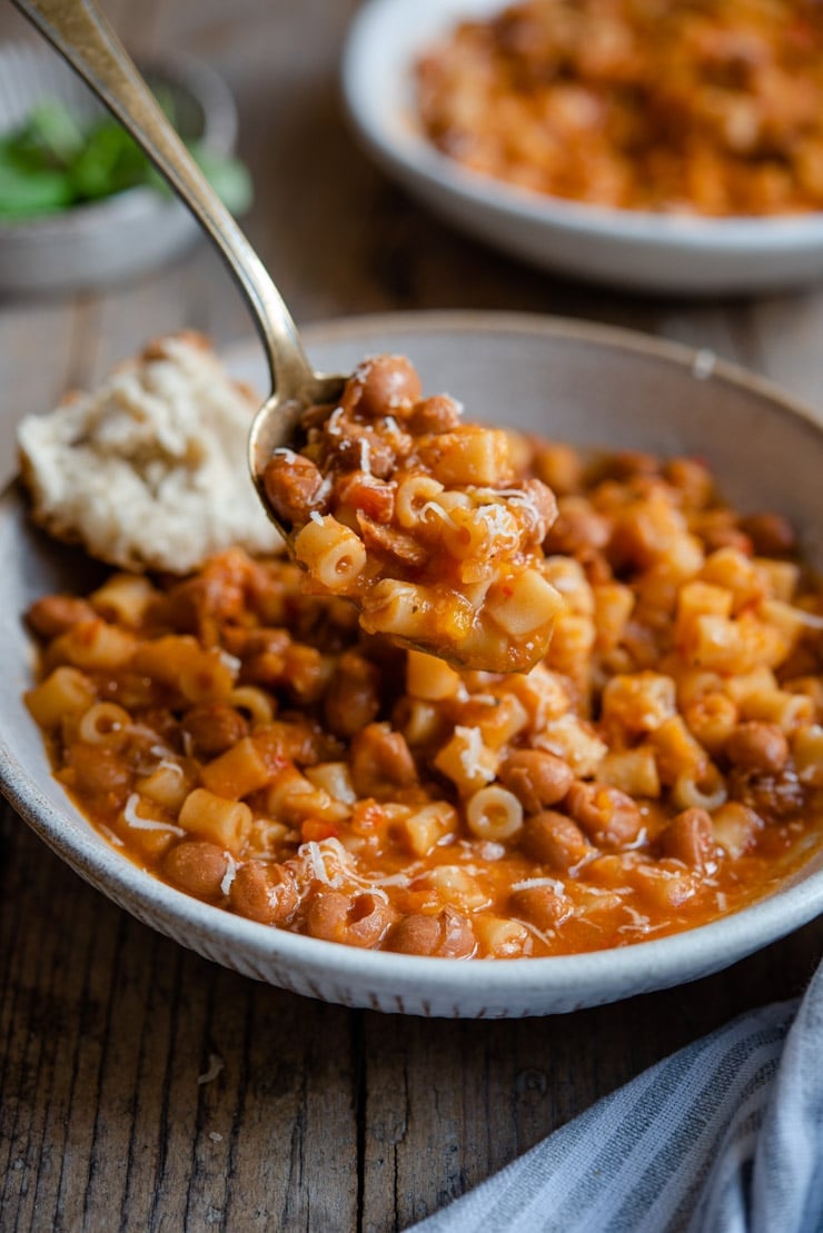 A close up of a spoonful of pasta fagioli soup