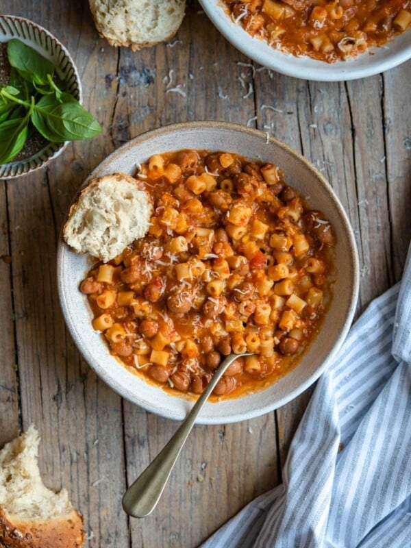 A bowl of pasta fagioli soup with crusty bread