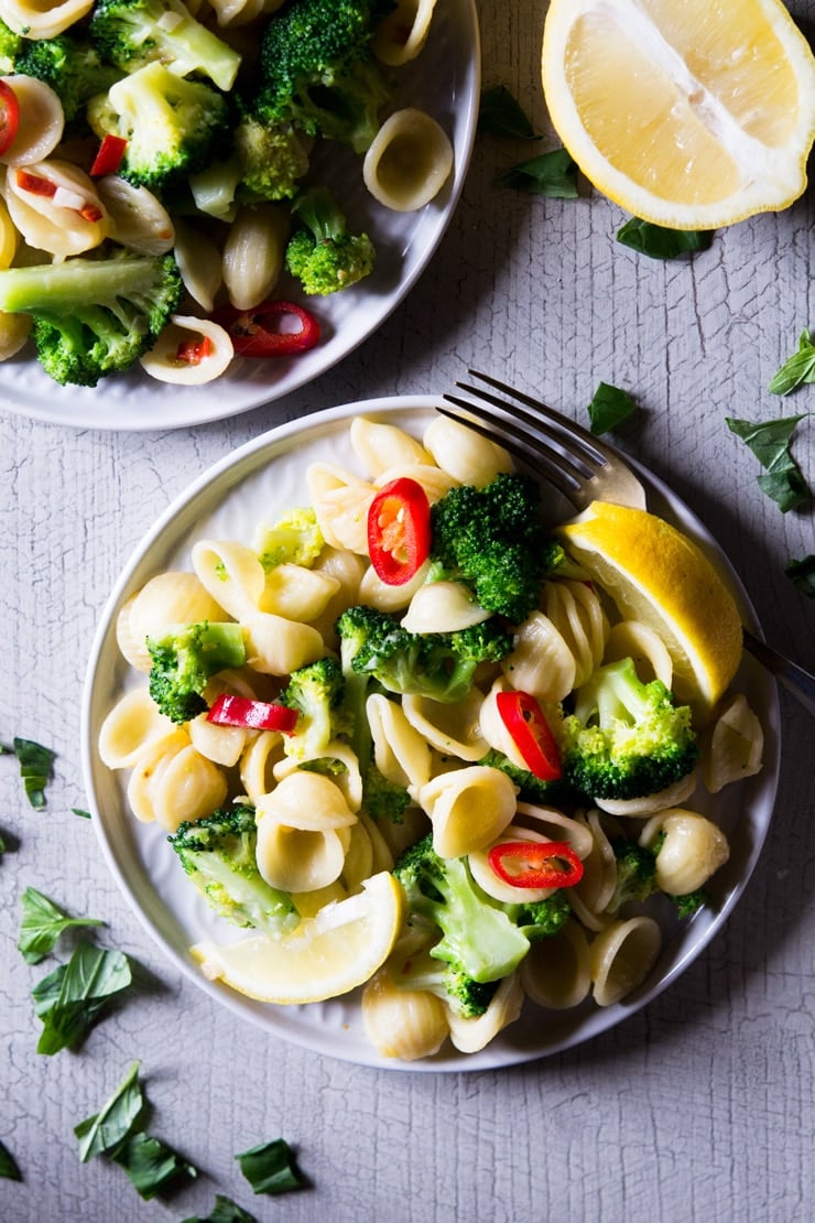 A close up of broccoli pasta on a plate the chopped fresh chilli and lemon scattered over the top