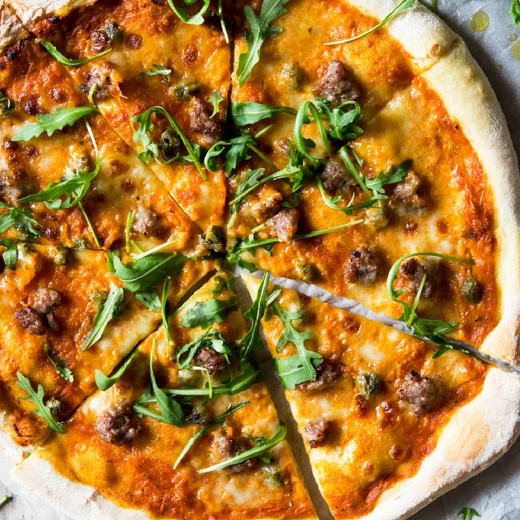 Pizza with sausage and roasted red pepper sauce