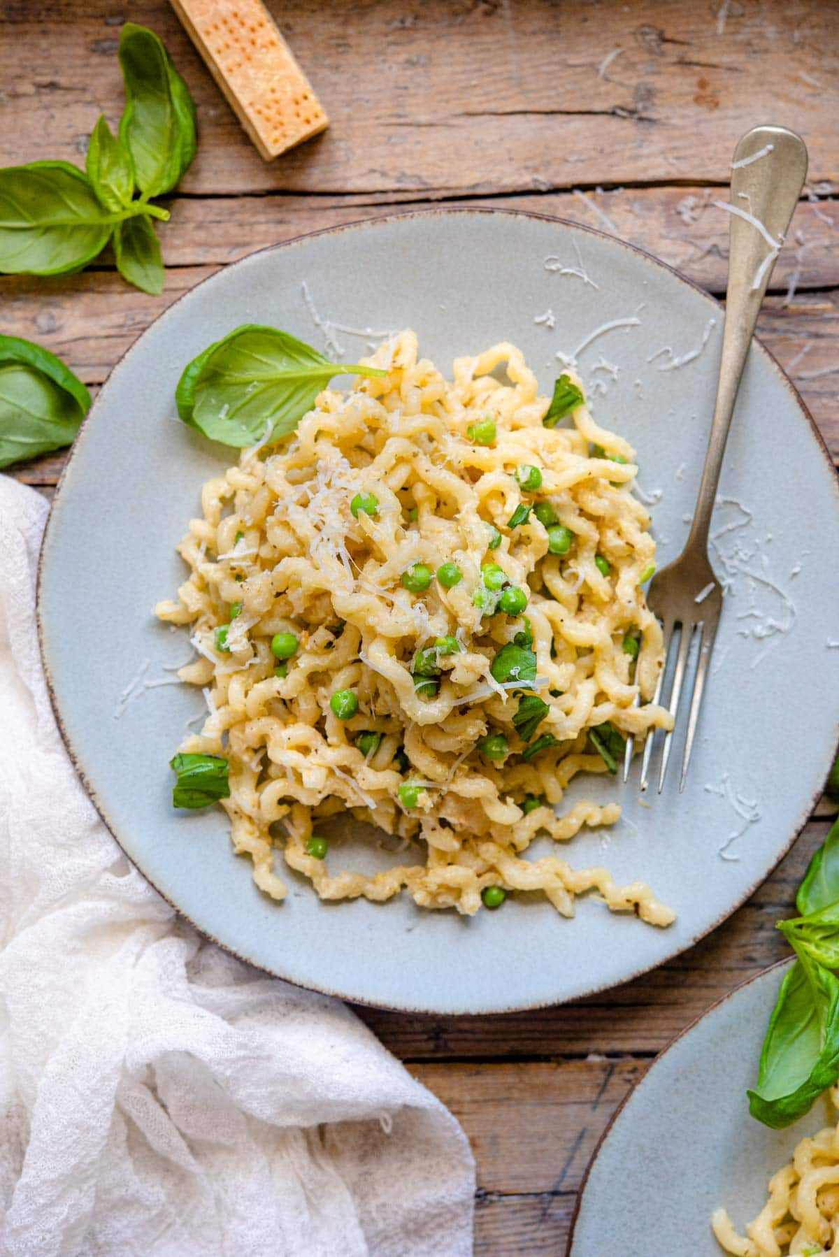 An overhead shot of artichoke pasta on a plate with basil