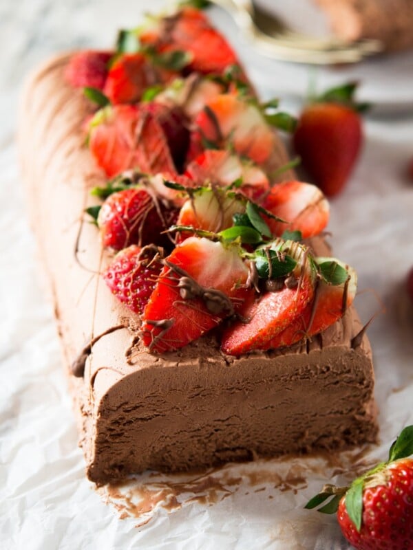 A chocolate semifreddo recipe on a white surface topped with fresh berries