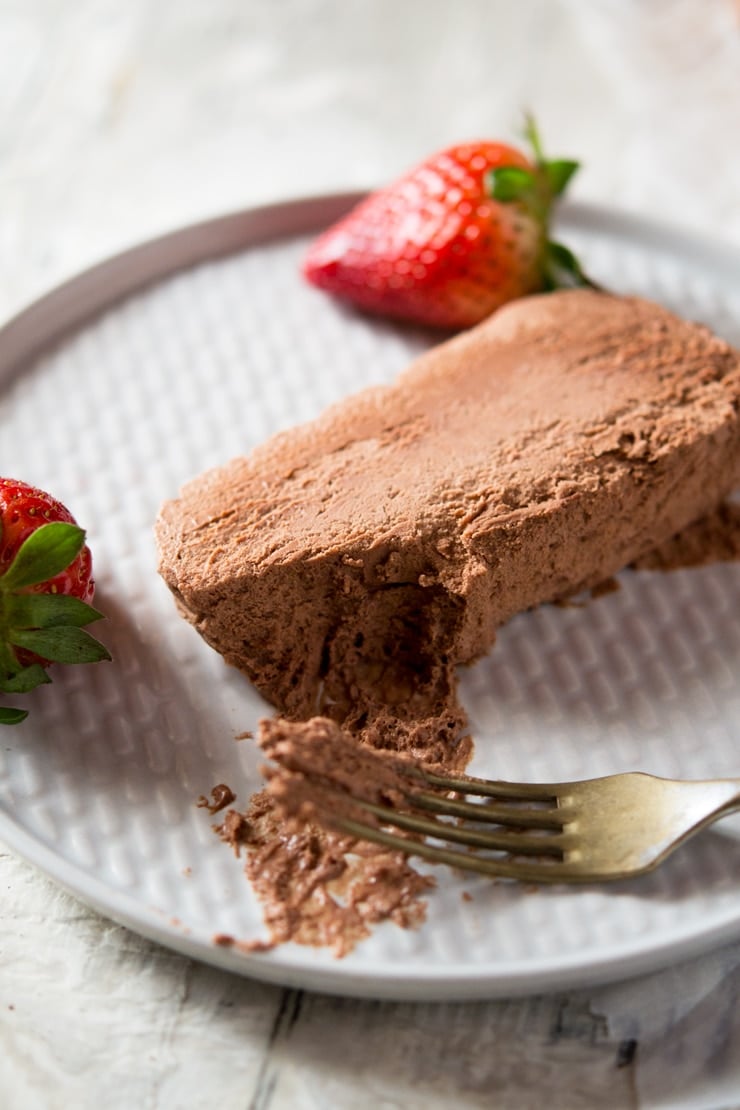 A close up of a slice chocolate semifreddo on a plate with a bite on a fork, an easy semifreddo recipe