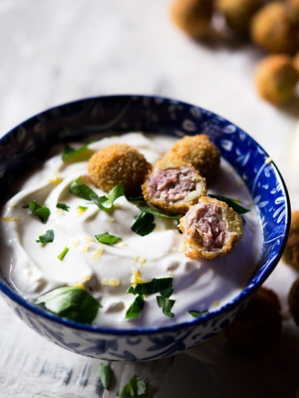 cut open stuffed olives with a sour cream dip