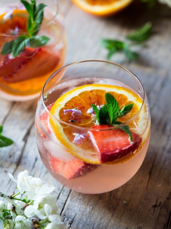 A close up of a sparkling rose cocktail with orange