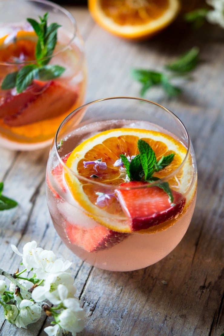 A close up of a sparkling rose cocktail with orange